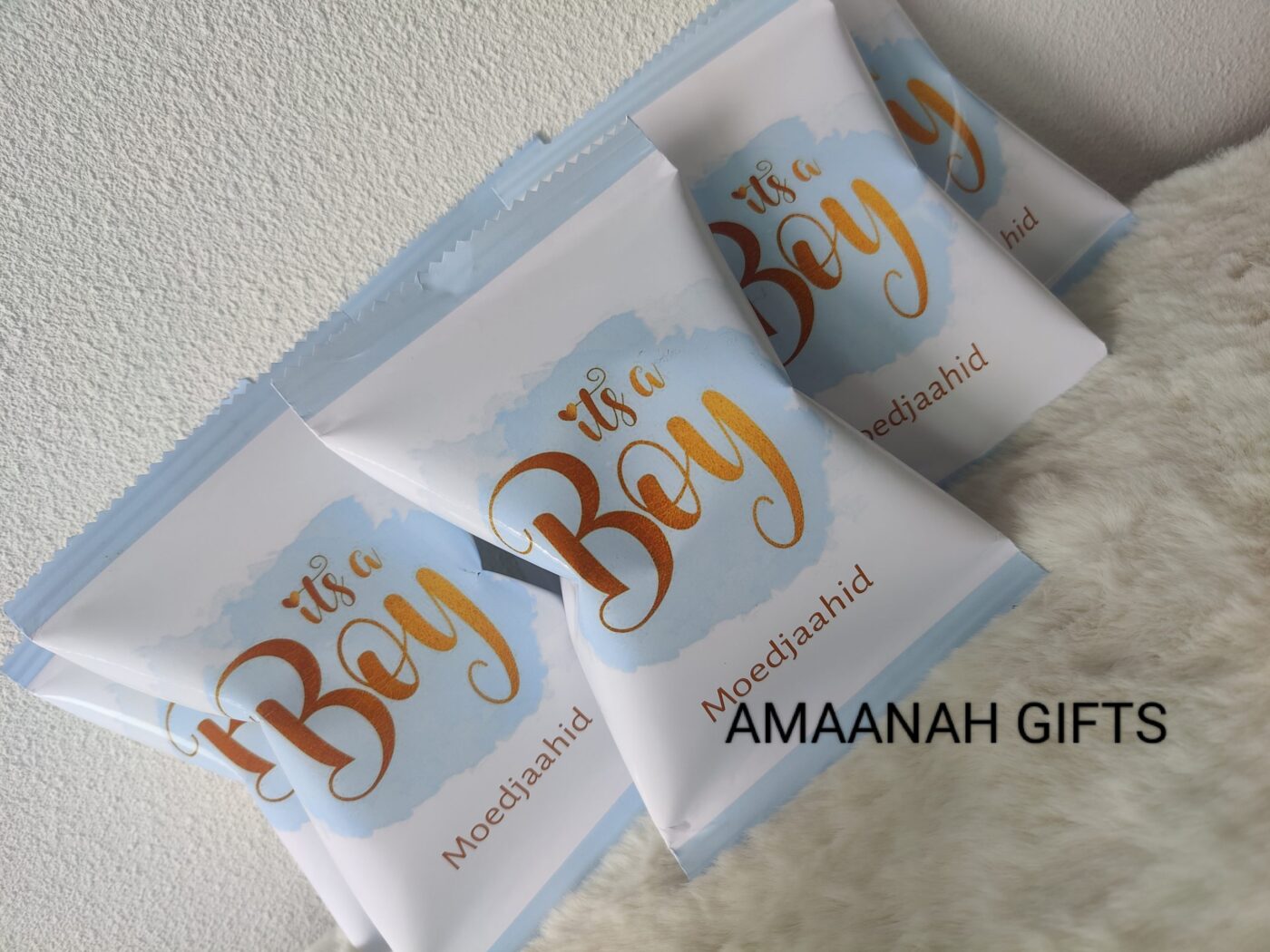 Gepersonaliseerde chipszakjes geboorte bedankje met de tekst "It's a Boy" en naam Moedjaahid op een blauwe aquarelachtergrond.