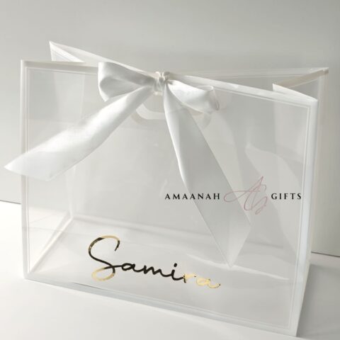 Transparante cadeau tas met naam en grote witte strik.